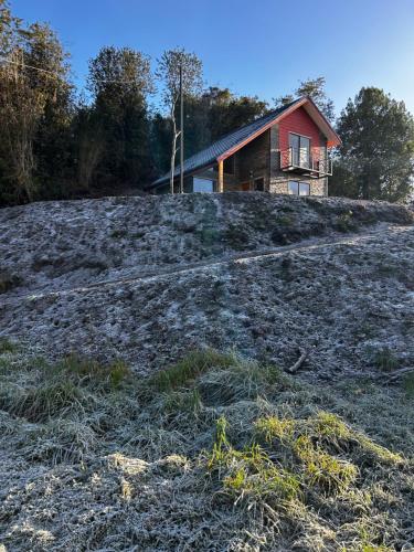 a house sitting on top of a hill withgrass at Cabaña del Llicanko in Achao