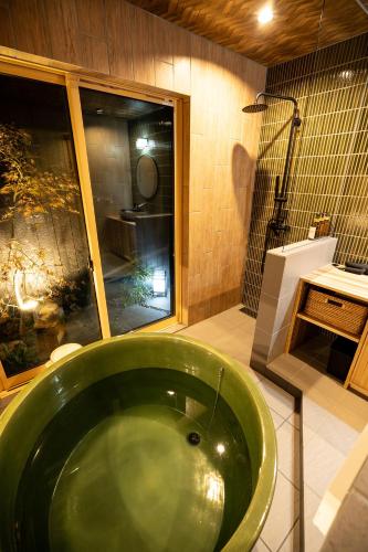 a green tub in a bathroom with a shower at 旅宿ありときりぎりす-近江八幡中心部で観光にお勧め in Omihachiman