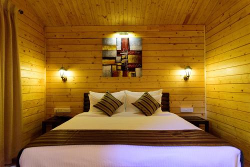 Un pat sau paturi într-o cameră la Tranquility Cottage Resorts