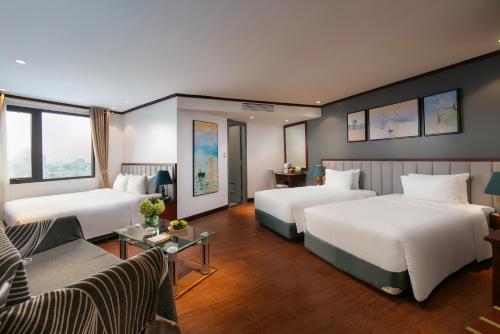 a hotel room with two beds and a couch at MAY DE VILLE Corner Hotel in Hanoi