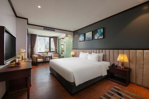 a bedroom with a large white bed and a desk at MAY DE VILLE Corner Hotel in Hanoi