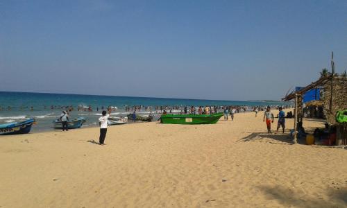 a group of people standing on a beach at Sea Zone Hotel Nilaveli in Nilaveli
