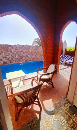 a patio with two chairs and a table and a pool at Luxor Tower in Luxor