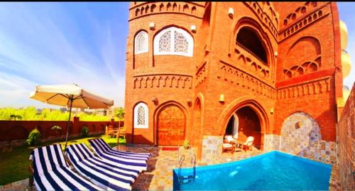 a brick building with a swimming pool in front of it at Luxor Tower in Luxor