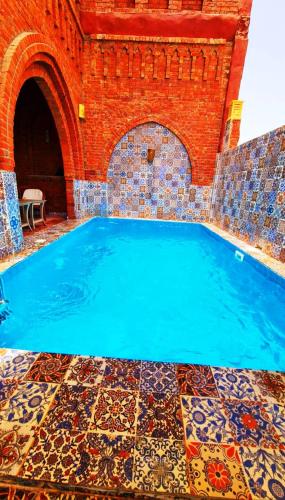 a swimming pool with a tile floor and a brick wall at Luxor Tower in Luxor