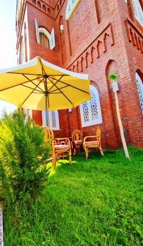 a yellow umbrella and chairs in front of a building at Luxor Tower in Luxor