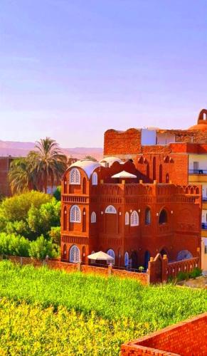 a red brick building in the middle of a field at Luxor Tower in Luxor