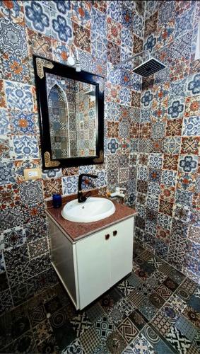 a bathroom with a sink and a mirror and tiles at Luxor Tower in Luxor