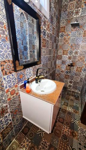 a bathroom with a sink and a mirror and tiles at Luxor Tower in Luxor