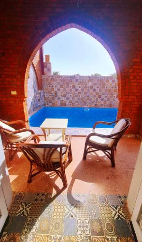 a patio with chairs and a table and a pool at Luxor Tower in Luxor