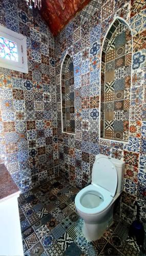 a bathroom with a toilet and mosaic tiles on the walls at Luxor Tower in Luxor