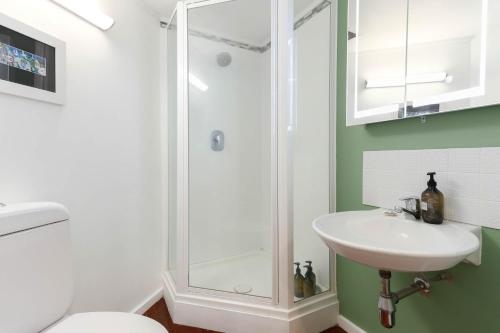 a bathroom with a shower and a sink at Studio Loft Apartment w bikes Wifi CBD in Auckland