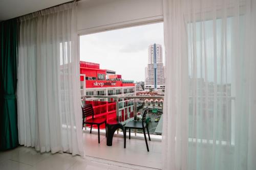 a room with a balcony with a table and chairs at SLEEP WITH ME HOTEL design hotel @ patong (SHA Plus+) in Patong Beach