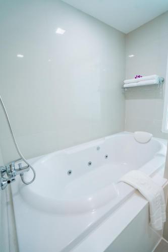 a white bathroom with a tub and a sink at SLEEP WITH ME HOTEL design hotel @ patong (SHA Plus+) in Patong Beach
