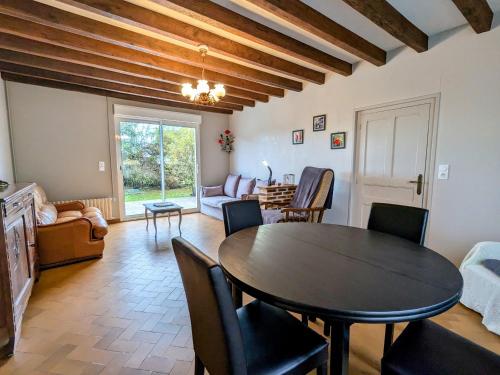 un salon avec une table et des chaises de salle à manger dans l'établissement Maison de campagne calme avec jardin, proche du Zoo de Beauval et châteaux de la Loire - FR-1-591-84, à Poulaines
