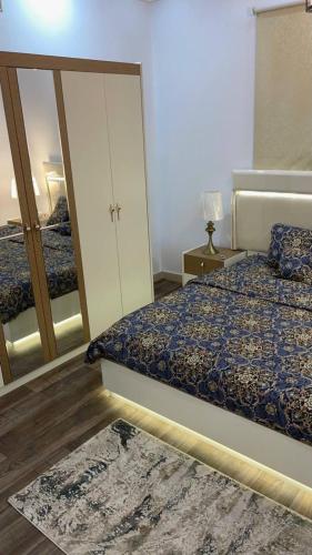 a bedroom with a bed and a large mirror at شقة رائعة لسياحة في جازان in Jazan