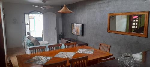 a dining room with a table and a mirror at Casa Ilhabela in Ilhabela