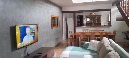 a living room with a couch and a dining room at Casa Ilhabela in Ilhabela