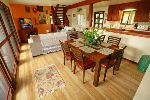 a dining room table and chairs in a living room at kehena black sand beach house - ocean view swim spa in Pahoa