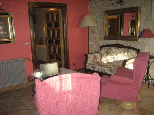 a room with a bed and two chairs and a table with a laptop at Arganzón Plaza in La Puebla de Arganzón