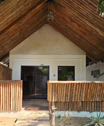 a house with a wooden roof and a porch at Big BamBoo Beach Resort Sipalay in Sipalay