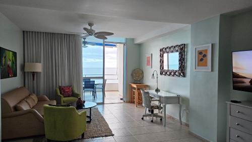 a living room with a couch and a table with a desk at Solarium Studio Apartment at Coronado Bay Oceanfront in Playa Coronado
