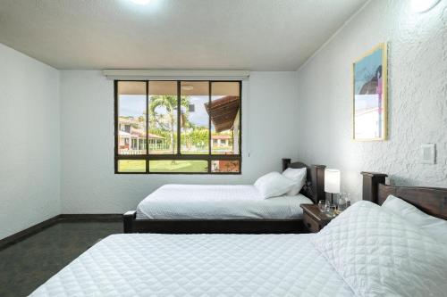 two beds in a room with a window at Hotel Chalet La Sofia by Majuva in Armenia