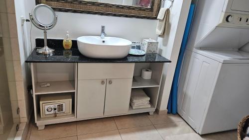 a bathroom vanity with a sink and a mirror at Solarium Studio Apartment at Coronado Bay Oceanfront in Playa Coronado