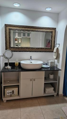a bathroom with a sink and a mirror at Solarium Studio Apartment at Coronado Bay Oceanfront in Playa Coronado