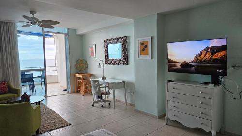 a living room with a flat screen tv on a dresser at Solarium Studio Apartment at Coronado Bay Oceanfront in Playa Coronado