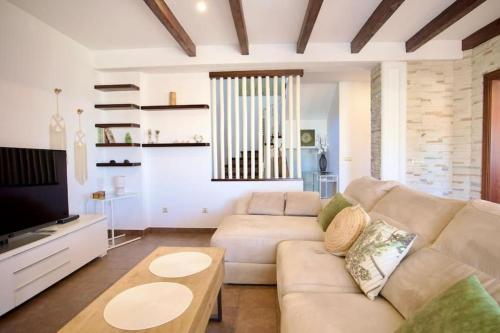 un soggiorno con un divano e una TV di Casa Carmen a Nerja