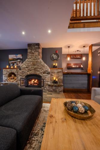 a living room with a couch and a stone fireplace at Winston Lodge in Golden