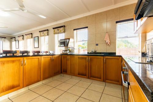 a large kitchen with wooden cabinets and a counter at Perna Perna Lodge St Lucia in St Lucia