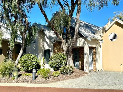 a house with a tree in front of it at SeventyThree at Cape View Resort in Broadwater