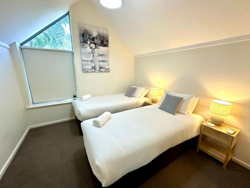 zwei Betten in einem Zimmer mit Fenster in der Unterkunft SeventyThree at Cape View Resort in Broadwater