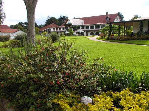 a garden in front of a large house at Brackenhurst Conference and Retreat Centre in Limuru