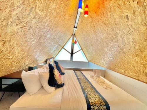 a room with a bed with a lamp on the wall at Banjert Villa Beach@สิชล in Ban Plai Thon