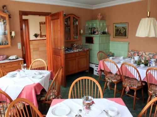 a dining room with tables and chairs and a kitchen at Gästehaus Mayer-Bartsch in Meersburg