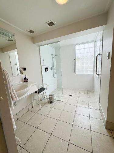 a bathroom with a tub and a sink and a shower at The Village Resort in Taupo