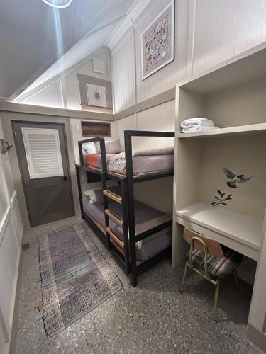 a small room with two bunk beds and a desk at The Headwaters Eco Lodge in Glenorchy