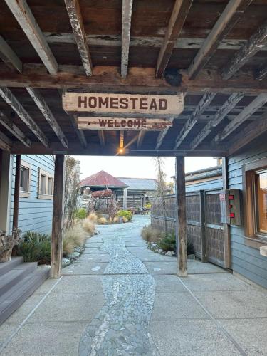 a house with a sign that reads homestead welcome at The Headwaters Eco Lodge in Glenorchy