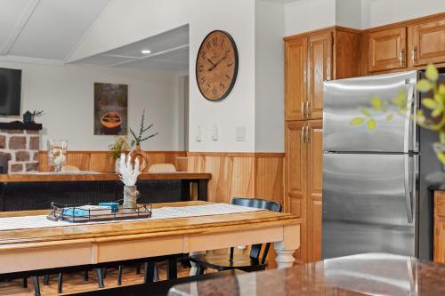 a kitchen with a table and a stainless steel refrigerator at Summit Shores Tranquil Escape Designed for Groups w Fire Pit Game Room in Lake Harmony