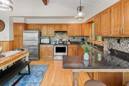 a kitchen with wooden cabinets and stainless steel appliances at Summit Shores Tranquil Escape Designed for Groups w Fire Pit Game Room in Lake Harmony