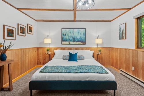 a bedroom with a large bed with blue pillows at Summit Shores Tranquil Escape Designed for Groups w Fire Pit Game Room in Lake Harmony