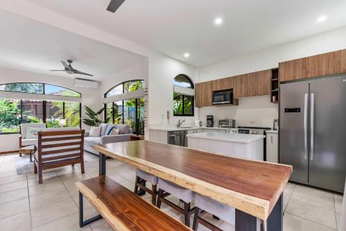 a kitchen and dining room with a wooden table at Pool Oasis, Concierge & 5min drive to the Beach in Playa Flamingo
