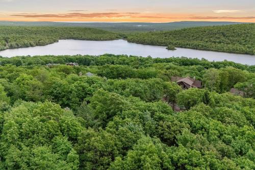 an aerial view of a lake and a house in the trees at Summit Shores Tranquil Escape Designed for Groups w Fire Pit Game Room in Lake Harmony