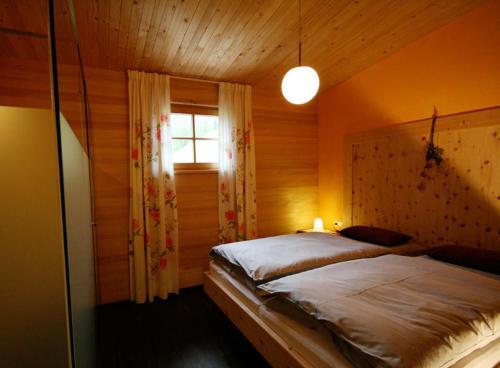 ein Schlafzimmer mit einem Bett in einem Zimmer mit einem Fenster in der Unterkunft Haus Rose in Schröcken