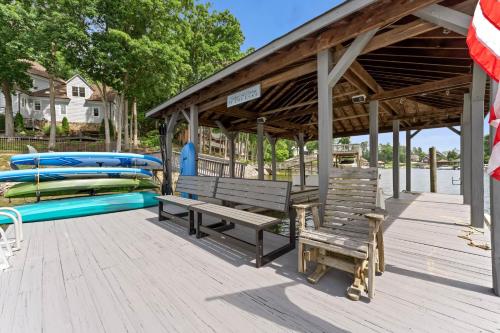 a wooden deck with two benches and a pool at Paradise Pointe by AvantStay Lakefront Views Playset in Lake Norman of Catawba