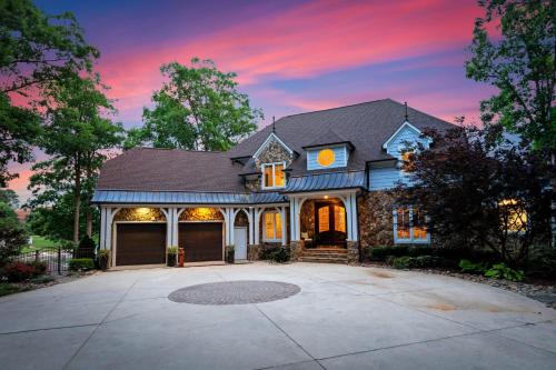 a house with a driveway in front of a sunset at Paradise Pointe by AvantStay Lakefront Views Playset in Lake Norman of Catawba