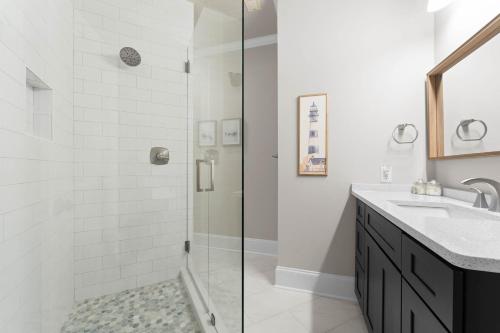 a white bathroom with a shower and a sink at Paradise Pointe by AvantStay Lakefront Views Playset in Lake Norman of Catawba